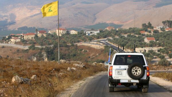 A UN peacekeepers (UNIFIL) vehicle drives past a Hezbollah flag in the southern Lebanese village of Khiam, near the border between Israel and Lebanon, 28 July 2020. - Sputnik International