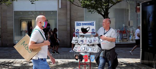 A man sells protective masks, as the city and surrounding area face local restrictions in an effort to avoid a local lockdown being forced upon the area, amid the coronavirus (COVID-19) outbreak, in Manchester - Sputnik International