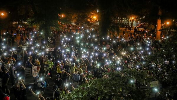 People shine cellphone flashlights during a demonstration against racial inequality and police violence in Portland, Oregon, U.S., July 29, 2020.  - Sputnik International