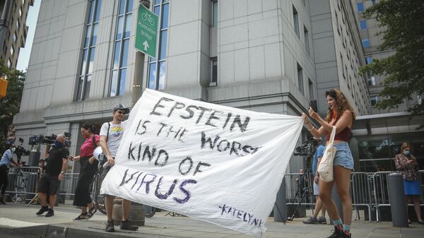 Multimedia artist Katelyn Kopenhaver, right, with help from her brother Brent Kopenhaver, unfurls a banner reading [Jefferey] Epstein is the worst kind of virus, outside federal court where a judge held a bail hearing by video for Epstein's former girlfriend Ghislaine Maxwell, Tuesday, July 14, 2020, in New York. - Sputnik International