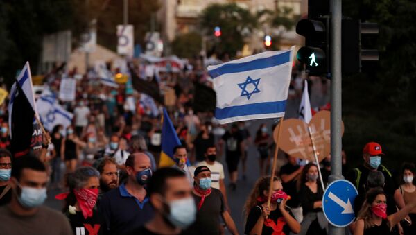 Israelis march as they protest against Israeli Prime Minister Benjamin Netanyahu and his government's response to the financial fallout of the coronavirus disease (COVID-19) crisis in Jerusalem July 21, 2020.  - Sputnik International