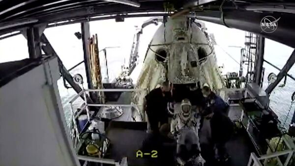An opened hatch of a capsule carrying NASA astronauts Robert Behnken and Douglas Hurley is seen as one of the astronauts exits it in the Gulf of Mexico, August 2, 2020, in this still image taken from a video. - Sputnik International