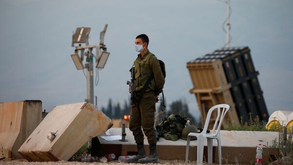 An Israeli soldier stands guard next to an Iron Dome anti-missile system near the Israel's northern border with Lebanon July 27, 2020 - Sputnik International