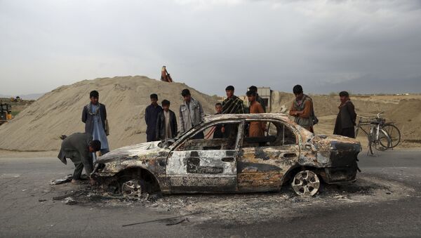 In this April 9, 2019, file photo, Afghans watch a civilian vehicle burnt after being shot by U.S. forces following an attack near the Bagram Air Base, north of Kabul, Afghanistan. Three American service members and a U.S. contractor were killed when their convoy hit a roadside bomb on Monday near the main U.S. base in Afghanistan, the U.S. forces said. The Taliban claimed responsibility for the attack. Intelligence alleging that Afghan militants might have accepted Russian bounties for killing American troops didn’t scuttle the U.S.-Taliban agreement or President Donald Trump’s plan to withdraw thousands more troops from the war - Sputnik International