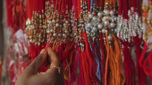 A woman shops for 'rakhi', or a sacred thread, ahead of 'Raksha Bandhan' festival in Hyderabad, India, Friday, July 31, 2020. - Sputnik International