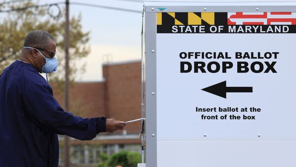 A resident drops off a mail-in ballot at the Edmondson Westside High School Polling site in Baltimore, Maryland, U.S., April 28, 2020 - Sputnik International