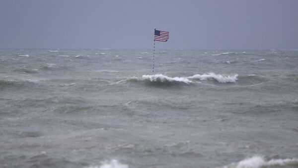 An American flag flies from the shipwreck of the Breconshire, as waves churned up by Tropical Storm Isaias crash around it, Sunday, Aug. 2, 2020, in Vero Beach, Fla. - Sputnik International