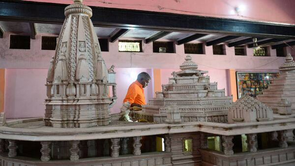 A worker walks past a model of a proposed Ram Hindu temple in Ayodhya on November 11, 2019. - Sputnik International