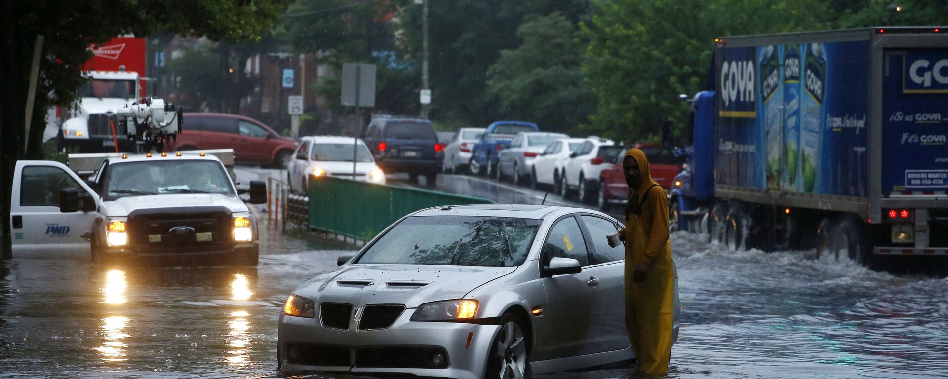 A man checks on a stranded vehicle during Tropical Storm Isaias, Tuesday, Aug. 4, 2020, in Philadelphia. The storm spawned tornadoes and dumped rain during an inland march up the U.S. East Coast after making landfall as a hurricane along the North Carolina coast. (AP Photo/Matt Slocum) - Sputnik International, 1920, 24.09.2023
