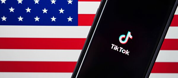 In this photo illustration, a mobile phone featuring the TikTok app is displayed next to the American flag on August 03, 2020 in New York City. Under threat of a U.S. ban on the popular social media app, it has been reported that Microsoft is considering taking over from Chinese firm ByteDance. In this photo illustration, a mobile phone featuring the TikTok app is displayed next to the American flag on August 03, 2020 in New York City. Under threat of a U.S. ban on the popular social media app, it has been reported that Microsoft is considering taking over from Chinese firm ByteDance. - Sputnik International