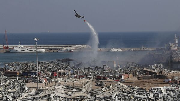 An army helicopter drops water at the scene of Tuesday's massive explosion that hit the seaport of Beirut, Lebanon, Wednesday, Aug. 5, 2020. Residents of Beirut awoke to a scene of utter devastation on Wednesday, a day after a massive explosion at the port sent shock waves across the Lebanese capital, killing dozens of people and wounding thousands.  - Sputnik International