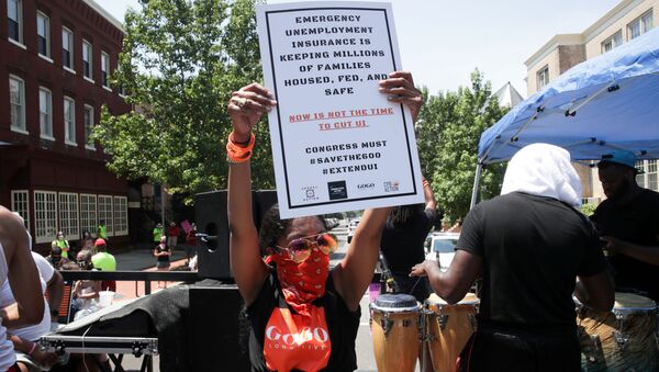 A person holds a placard as protesters temporarily block the street to U.S. Senate Majority Leader Mitch McConnell's (R-KY) house with a live band on a flatbed truck, demanding the extension of coronavirus disease (COVID-19)-related unemployment aid, on Capitol Hill in Washington, U.S. July 22, 2020 - Sputnik International