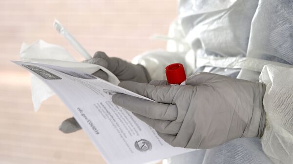A nurse prepares to administer a polymerise chain reaction (PCR) test to detect the presence of the COVID-19 antigen, at a testing site affiliated with the Methodist Health System, in Omaha, Neb., Friday, April 24, 2020. (AP Photo/Nati Harnik) - Sputnik International