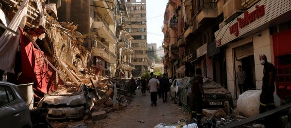 People walk past damaged buildings and vehicles following Tuesday's blast in Beirut's port area, Lebanon 5 August 2020. - Sputnik International