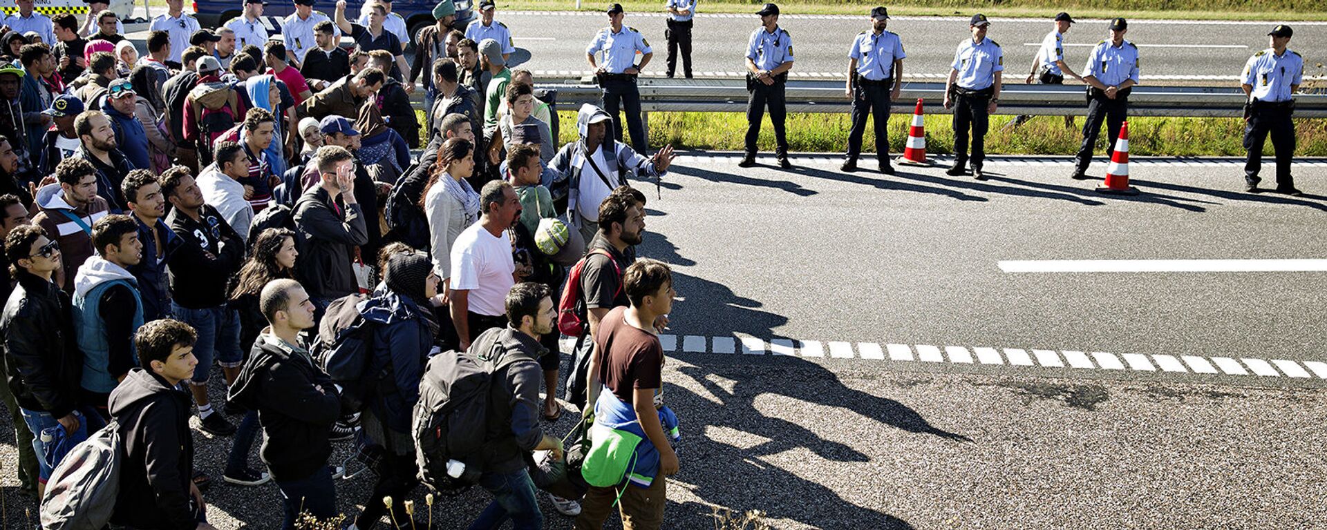 FILE - In this Sept. 9, 2015 file picture hundreds of refugees walk in Southern Jutland motorway near Padborg in Denmark - Sputnik International, 1920, 25.01.2021
