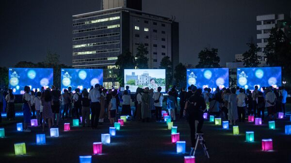 Visitors watch a screen (back C) displaying virtual lanterns as paper lanterns are placed to mark the 75th anniversary of the atomic bombing, at a park in in Hiroshima on August 6, 2020. - Japan on August 6, 2020 marked 75 years since the world's first atomic bomb attack, with the COVID-19 coronavirus pandemic forcing a scaling back of annual ceremonies to commemorate the victims. - Sputnik International
