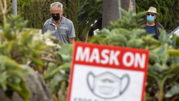 People wear masks as they walk along the side walk during the outbreak of the coronavirus disease (COVID-19) in Del Mar, California, U.S., July 30, 2020. - Sputnik International