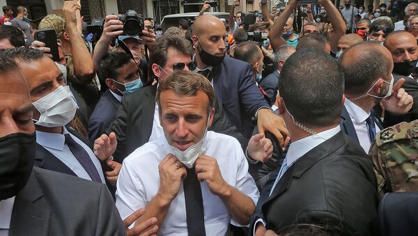 French President Emmanuel Macron adjusts his protective mask as he visits the Gemmayzeh neighbourhood which has suffered extensive damage due to a massive explosion in the Lebanese capital, on August, 6. 2020. - Sputnik International