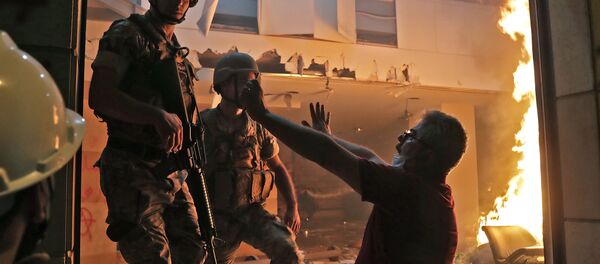 A Lebanese protester speaks to soldiers at the headquarters of the Lebanese association of banks in downtown Beirut on August 8, 2020, following a demonstration against a political leadership they blame for a monster explosion that killed more than 150 people and disfigured the capital Beirut. - Sputnik International