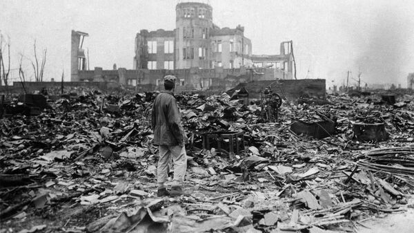 A correspondent stands in a sea of rubble before the shell of a building that once was a movie theater in Hiroshima Sept. 8, 1945, a month after the first atomic bomb ever used in warfare was dropped by the U.S. - Sputnik International