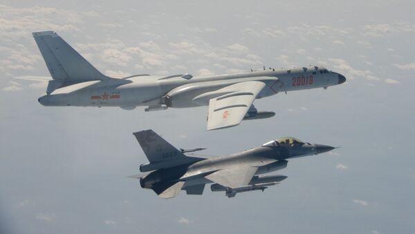 This handout photo taken and released on 10 February 2020 by Taiwan's Defence Ministry shows a Taiwanese F-16 fighter jet flying next to a Chinese H-6 bomber (top) in Taiwan's airspace. - Sputnik International
