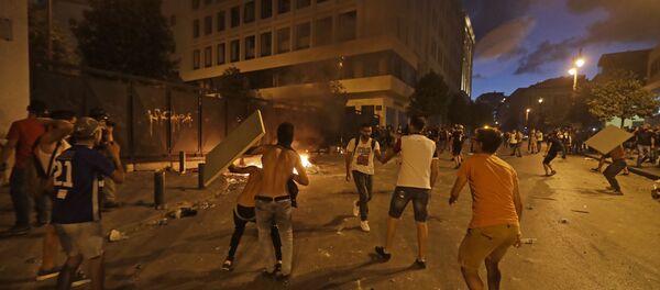 Lebanese protesters, enraged by a deadly explosion blamed on government negligence, clash with security forces for the second evening near an access street to the parliament in central Beirut on August 9, 2020. - Sputnik International