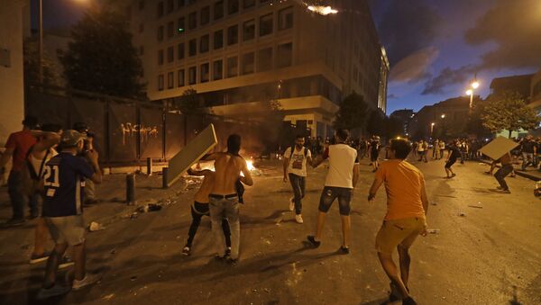 Lebanese protesters, enraged by a deadly explosion blamed on government negligence, clash with security forces for the second evening near an access street to the parliament in central Beirut on August 9, 2020. - Sputnik International