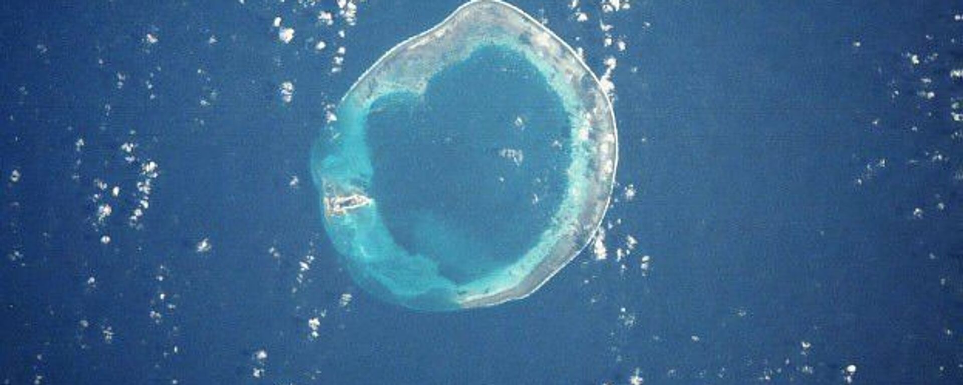 Satellite photo of Pratas (Dongsha) Island, a 590-acre island which sits 270 miles south of Taiwan and 200 miles east of China in the South China Sea. It is controlled by Taiwan. The island is on the left side - the rest is submerged reef. - Sputnik International, 1920, 07.11.2021