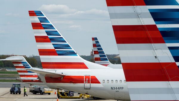 A member of a ground crew walks past American Airlines planes parked at the gate during the coronavirus disease (COVID-19) outbreak at Ronald Reagan National Airport in Washington, U.S., April 5, 2020.  - Sputnik International