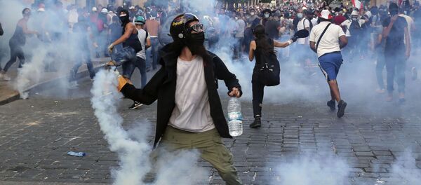 Protesters throw back tear gas canisters towards riot policemen during an anti-government protest, in the aftermath of last Tuesday's massive explosion which devastated Beirut, Lebanon, Monday, Aug. 10, 2020 - Sputnik International