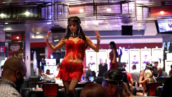 FILE PHOTO: A woman wears a face shield as she dances behind blackjack tables during the reopening of The D hotel-casino, in downtown Las Vegas, Nevada, U.S. June 4, 2020 - Sputnik International