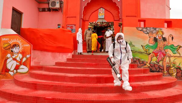 A municipal worker wearing protective gear sprays disinfectant at Hanuman Garhi temple before the arrival of India's Prime Minister Narendra Modi ahead of the foundation laying ceremony for a Hindu temple in Ayodhya, India, August 5, 2020 - Sputnik International