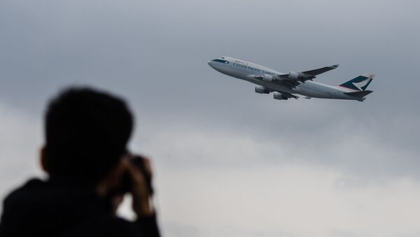 This file photo taken on March 15, 2017 shows an aviation enthusiast photographing a Cathay Pacific cargo aircraft as it takes off from the international airport in Hong Kong. - Troubled Hong Kong carrier Cathay Pacific said it lost 1.27 billion USD in the first half of this year, the latest major airline to reveal how badly the COVID-19 coronavirus pandemic has eviscerated its business.  - Sputnik International