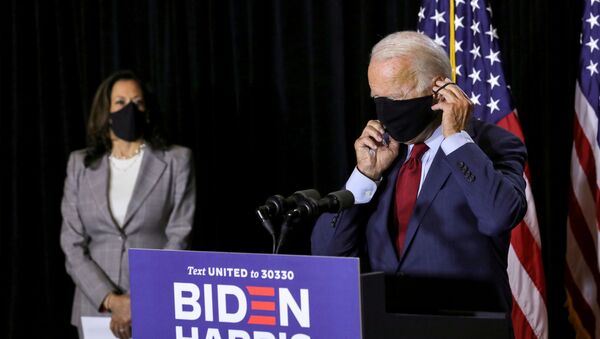 Democratic U.S.presidential candidate Joe Biden, accompanied by Democratic U.S. vice presidential candidate Kamala Harris, adjusts his protective face mask as he calls for the mandatory wearing of masks while speaking to reporters following a briefing on the coronavirus disease (COVID-19) pandemic with public health experts during a campaign event in Wilmington, Delaware, U.S., August 13, 2020.  - Sputnik International