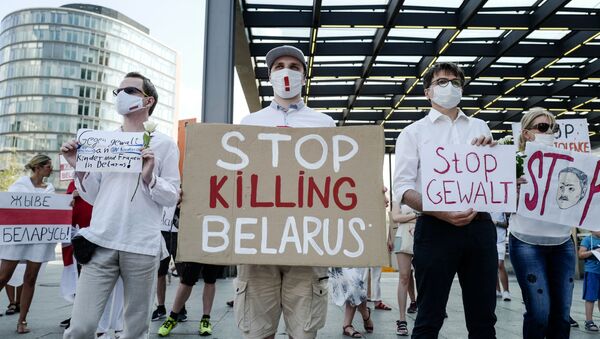 A protester holds a sign reading Stop Killing Belarus during a demonstration on the contested elections in Belarus in Berlin, on August 15, 2020. - Sputnik International