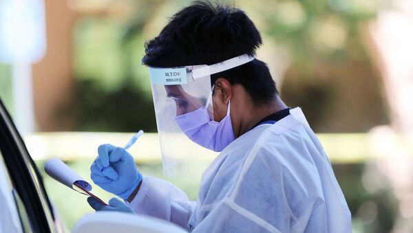 A healthcare worker gathers information from a motorist at a drive-in coronavirus (COVID-19) testing center at M.T.O. Shahmaghsoudi School of Islamic Sufism on August 11, 2020 in Los Angeles, California. California reported 12,500 new cases after backlogged cases from a data glitch began appearing in the states system. - Sputnik International