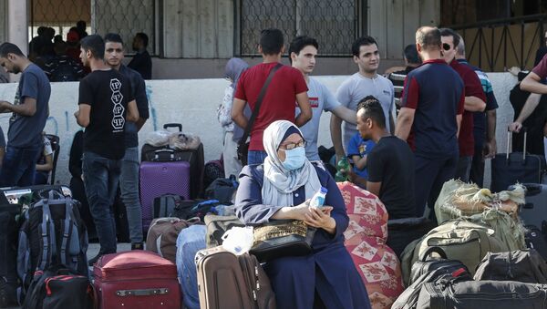 Palestinians wait to cross to the Egyptian side of Rafah border crossing after months of closure due to the coronavirus pandemic in the southern Gaza Strip, on August 11, 2020.  - Sputnik International
