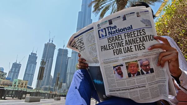 A man reads a copy of UAE-based The National newspaper near the Burj Khalifa, the tallest structure and building in the world since 2009, in the gulf emirate of Dubai on August 14, 2020, as the publication's headline reflects the previous day's news as Israel and the UAE agreed to normalise relations in a landmark US-brokered deal. - The deal marks only the third such accord the Jewish state has struck with an Arab nation, an historic shift making the Gulf state only the third Arab country to establish full diplomatic ties with the Jewish state. The Palestinian leadership voiced its strong rejection and condemnation of the deal and announced it would withdraw its envoy from the UAE, and Turkey also condemned the deal as an act of treachery. - Sputnik International