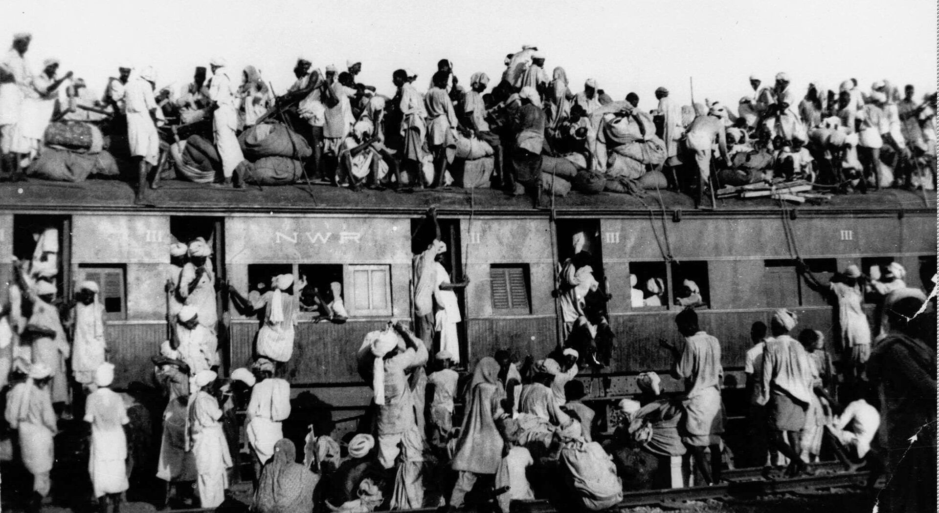 In this September 1947, file photo hundreds of Muslim refugees crowd on top a train leaving New Delhi for Pakistan. After Britain ended its colonial rule over the Indian subcontinent, two independent nations were created in its place _ the secular, Hindu-majority nation of India, and the Islamic republic of Pakistan. The division, widely referred to as Partition, sparked massive rioting that killed up to 1 million, while another 15 million fled their homes in one of the world’s largest ever human migrations. (AP Photo, File) - Sputnik International, 1920, 07.10.2022