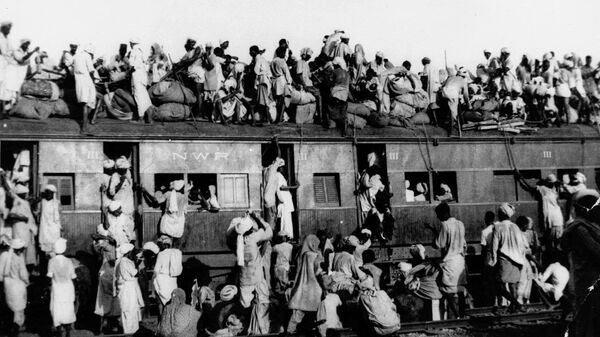In this September 1947, file photo hundreds of Muslim refugees crowd on top a train leaving New Delhi for Pakistan. After Britain ended its colonial rule over the Indian subcontinent, two independent nations were created in its place _ the secular, Hindu-majority nation of India, and the Islamic republic of Pakistan. The division, widely referred to as Partition, sparked massive rioting that killed up to 1 million, while another 15 million fled their homes in one of the world’s largest ever human migrations. (AP Photo, File) - Sputnik International