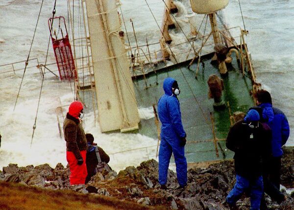 Members of the media with masks on their faces watch the wreckage of the oil tanker Braer that ran aground during a storm off Shetland, Scotland, in January 1993 and broke up a week later following storm force winds. - Sputnik International