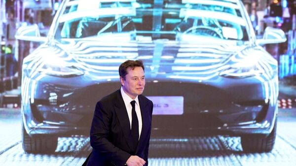 Tesla Inc CEO Elon Musk walks next to a screen showing an image of Tesla Model 3 car during an opening ceremony for Tesla China-made Model Y program in Shanghai, China January 7, 2020 - Sputnik International