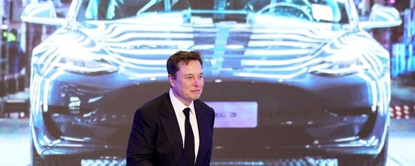 Tesla Inc CEO Elon Musk walks next to a screen showing an image of Tesla Model 3 car during an opening ceremony for Tesla China-made Model Y program in Shanghai, China January 7, 2020 - Sputnik International
