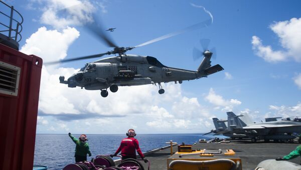 An MH-60R Seahawk assigned to the “Saberhawks” of Helicopter Maritime Strike Squadron (HSM) 77 lifts off the flight deck of America’s only forward-deployed aircraft carrier USS Ronald Reagan (CVN 76)  while conducting operations in the South China Sea. - Sputnik International