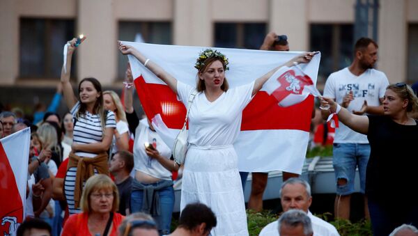 A woman holds a historical white-red-white flag of Belarus as she attends an opposition demonstration to protest against presidential election results, in Independence Square in Minsk, Belarus August 18, 2020 - Sputnik International