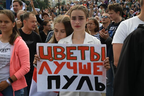 A woman holds a banner with Flowers are better than bullets written on it during a rally in Minsk, Belarus on 15 August, 2020. - Sputnik International
