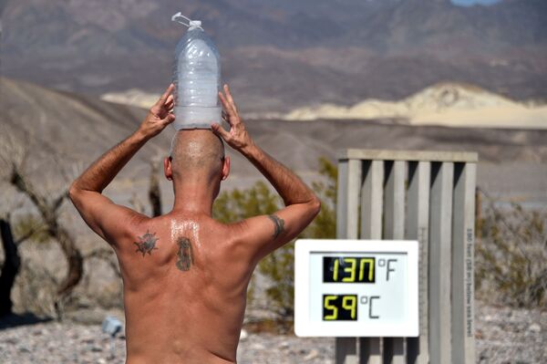 Steve Krofchik of Las Vegas keeps cool with a bottle of ice on his head as the thermometer reads 130 degrees Fahrenheit (54.4 Celsius) at the Furnace Creek Visitors Centre in Death Valley, California, 17 August 2020.  - Sputnik International