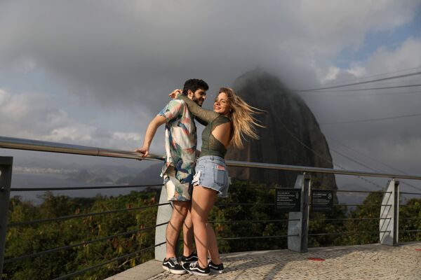 A couple stands with Sugarloaf Mountain in the background during reopening after a months-long closure due to the outbreak of the coronavirus disease (COVID-19), in Rio de Janeiro, Brazil, 15 August 2020.  - Sputnik International