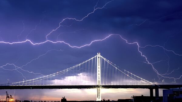 Lightning forks over the San Francisco-Oakland Bay Bridge as a storm passes over Oakland, Calif., Sunday, Aug. 16, 2020. - Sputnik International