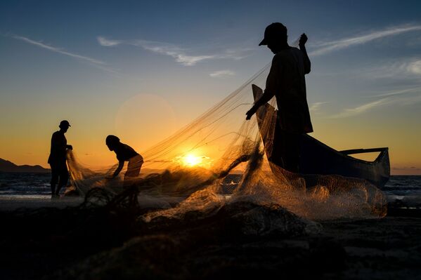 Fishermen clean their nets after fishing at sunset in Banda Aceh, Sumatra, Indonesia, on 19 August, 2020. - Sputnik International